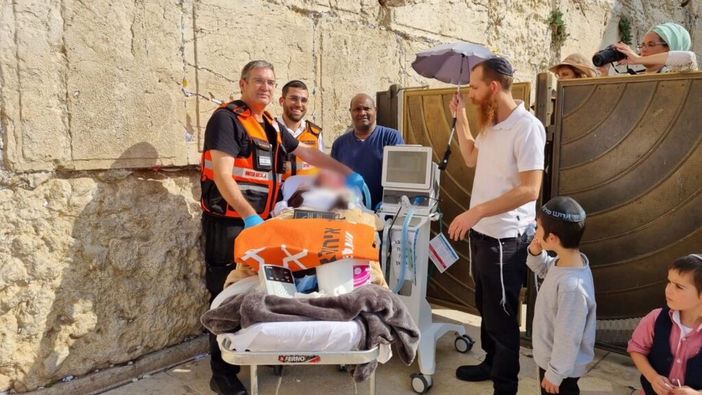 Yosef Yitzchak at the Western Wall with United Hatzalah medical personnel a nurse from Herzog Hospital center and relatives 1024x576 1