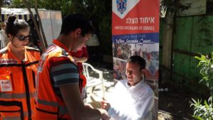 Eliana and Avner in their EMT vests during a health fair at the home of the British Ambassador to Israel