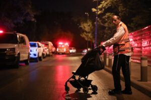 A United Hatzalah EMT picks up an abandoned baby carriage after the shooting attack 300x200 1
