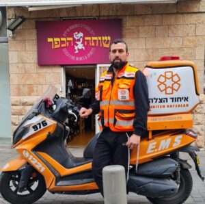 Chezi Roth with his ambucycle in front of his store 300x298 1