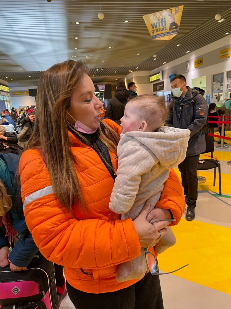 Einat holds a baby at the Iasi airport to give the young mother a few minutes to relax 768x1024 2