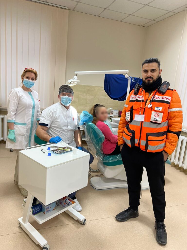 Reuven together with his colleagues providing dental care in Chisinau for a Ukrainian refugee censored 768x1024 2