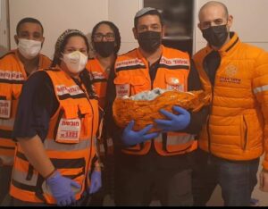 United Hatzalah volunteers pose with a newborn infant after an emergency home birth illustration.v1 2 300x234 1