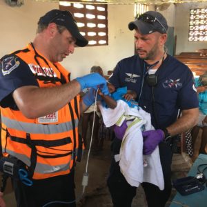 CEO of JET911 Eli Rowe (right) together with Dovi Maisel (left) treating a child in Haiti