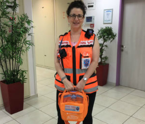 (Photo: Melanie Berkowitz receiving the defibrillator that she uses to save lives from United Hatzalah - Courtesy Melanie Berkowitz)