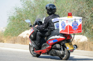 (Photo: An EMT on an ambucycle riding to an emergency Credit: United Hatzalah)