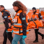 Volunteers carrying patient on backboard